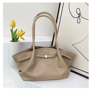 Detail view of beige winged tote bag featuring elegant metal buckle and premium leather folds