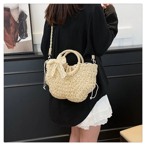 Vue détaillée du sac de plage en paille tressée avec nœud en dentelle sur mannequin