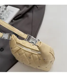 Detail showing beige quilted handbag texture with metal studs and silver buckle