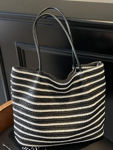 Large striped straw tote bag with black leather straps for summer beach vacations