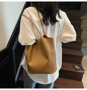 Detailed view of the brown crocodile pattern leather texture on a large shoulder tote bag