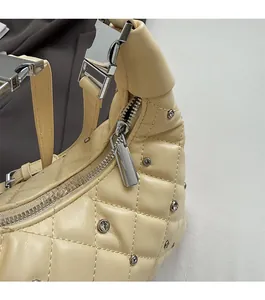 Detail view of the quilted leather bag featuring a smooth metal zipper and silver buckle