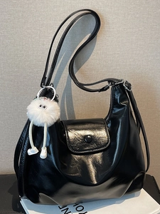 Glossy black hobo shoulder bag with silver buckle and white plush mascot charm for women