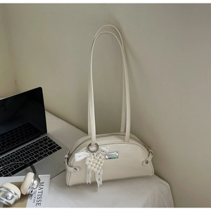 Détail du nœud en dentelle crème et pendentif cœur perlé sur le sac en similicuir