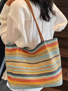 Large colorful striped straw tote bag with brown leather straps for beach holidays