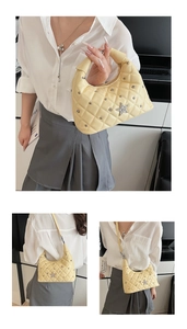 Detail of light yellow quilted handbag with star-shaped rhinestone metal hardware