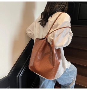 Close-up of brown crocodile pattern leather tote bag worn on shoulder for commute