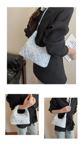 Detail of light blue quilted bag with silver rhinestone star and metal stud decorations