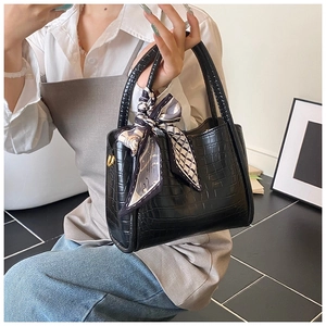 Détails du sac seau noir motif crocodile avec foulard en soie élégant sur la poignée