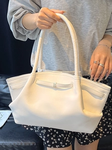 Minimalist white leather tote bag for women featuring a spacious design and slim handles