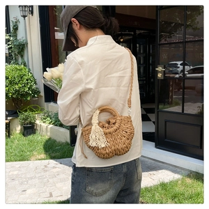 Détail du sac à main en paille tressée avec franges en dentelle et cordon de serrage