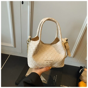 Détail du sac seau tressé blanc cassé avec logo doré et texture en cuir synthétique