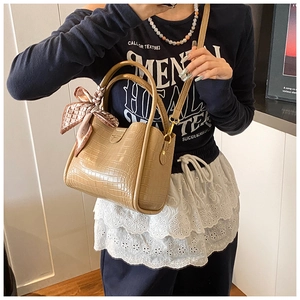 Détail du sac seau kaki avec motif croco et foulard décoratif sur la poignée