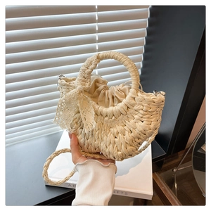 Détail du sac en paille demi-lune avec nœud en dentelle et doublure à cordon