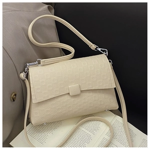 Detail of off-white lychee grain leather crossbody bag with silver hardware and strap