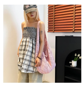 Detail of pink hand-woven hollow knit shoulder bag with intricate bohemian texture