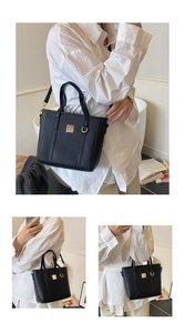 Detail of black lychee-grain bucket bag with golden metal hardware and adjustable strap