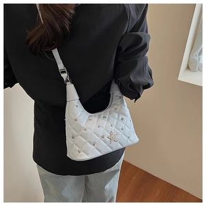 Detail of light blue quilted leather shoulder bag with silver studs and star emblem
