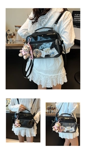 Detail view of black Ita bag with transparent PVC window and plush fox charm