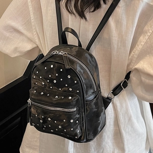 Mini sac à dos noir à clous argentés et bretelles réglables porté par un mannequin