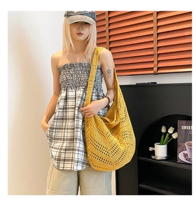 Detailed texture of yellow bohemian hollow crochet woven bag for summer beach style