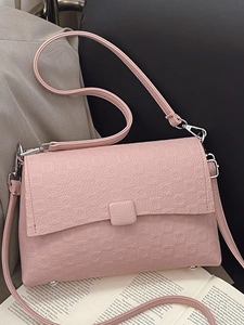 Pink lychee grain leather crossbody bag with silver hardware on elegant prop background