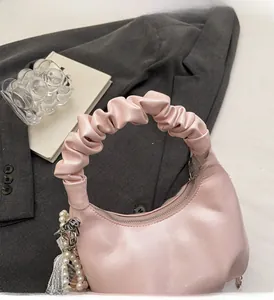 Detail of pink pleated handbag with pearl lace charm and silver hardware accents
