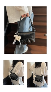 Détail du sac à bandoulière plissé noir avec breloque cœur perle et sangle nouée