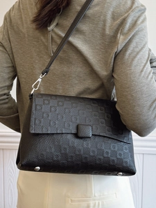 Elegant black embossed leather crossbody square bag with geometric patterns and silver strap