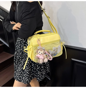 Detail of yellow PVC jelly bag with transparent window, crossbody strap and plush bear charm