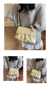 Détail du sac plissé jaune crème avec nœud en dentelle et perles sur cuir de haute qualité
