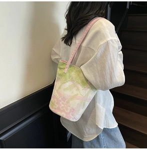 Détail d'un sac cabas en toile avec motif floral et bandoulière en sangle rose