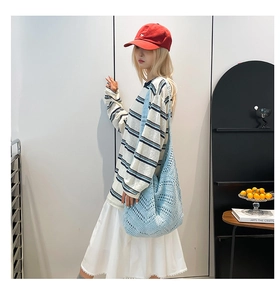 Close-up of light blue hollow-out woven shoulder bag in a lifestyle indoor setting
