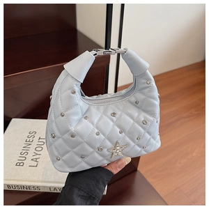 Detail of light blue quilted handbag featuring silver star rhinestone and metallic studs