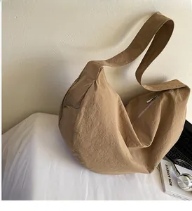 Close-up of khaki woven large tote bag with zipper detail and smooth nylon texture