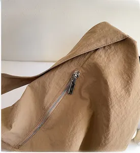 Close-up of smooth silver metal zipper on a khaki woven textured tote bag detail