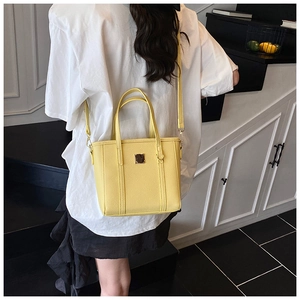 Detail of yellow lychee texture crossbody bag with metal buckle on a model