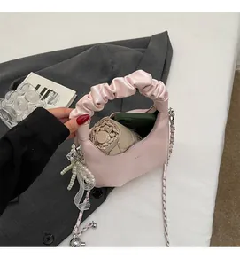 Detail view of the spacious pink pleated handbag interior with pearl pendant and lace bow