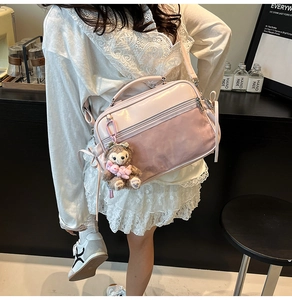 Pink transparent ita bag with clear window and shoulder strap shown on a model