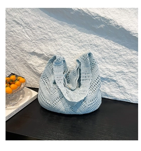 Detail shot of light blue hand-woven crochet hobo bag with hollow wave patterns