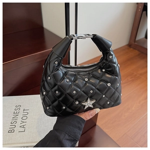Detail showing the black quilted handbag with star rhinestone and silver buckle finish