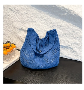 Detail of royal blue hand-woven crochet bag with delicate hollow geometric patterns