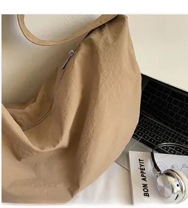 Close-up of khaki woven tote bag with smooth metal zipper and soft fabric texture