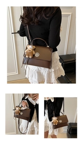 Detail of dark brown leather handbag featuring a metal twist lock and cute bear charm