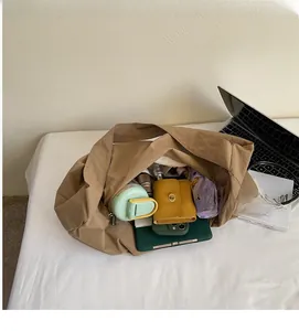 Spacious interior of a brown tote bag filled with a thermos bottle, wallet, and phone