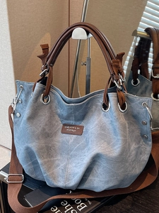 Retro blue denim tote bag with brown leather handles and adjustable shoulder strap for women
