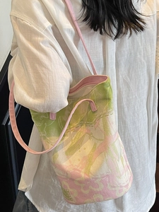 Sac fourre-tout en toile à imprimé floral avec poignées en cuir rose porté par un modèle