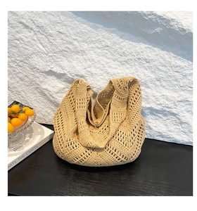 Detail shot of boho woven shoulder bag featuring intricate hollow-out crochet pattern texture