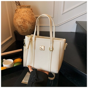 Close-up of cream white lychee leather bucket bag with elegant square gold hardware detail
