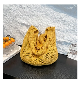 Detail of bohemian yellow hand-woven crochet tote bag featuring intricate hollow patterns